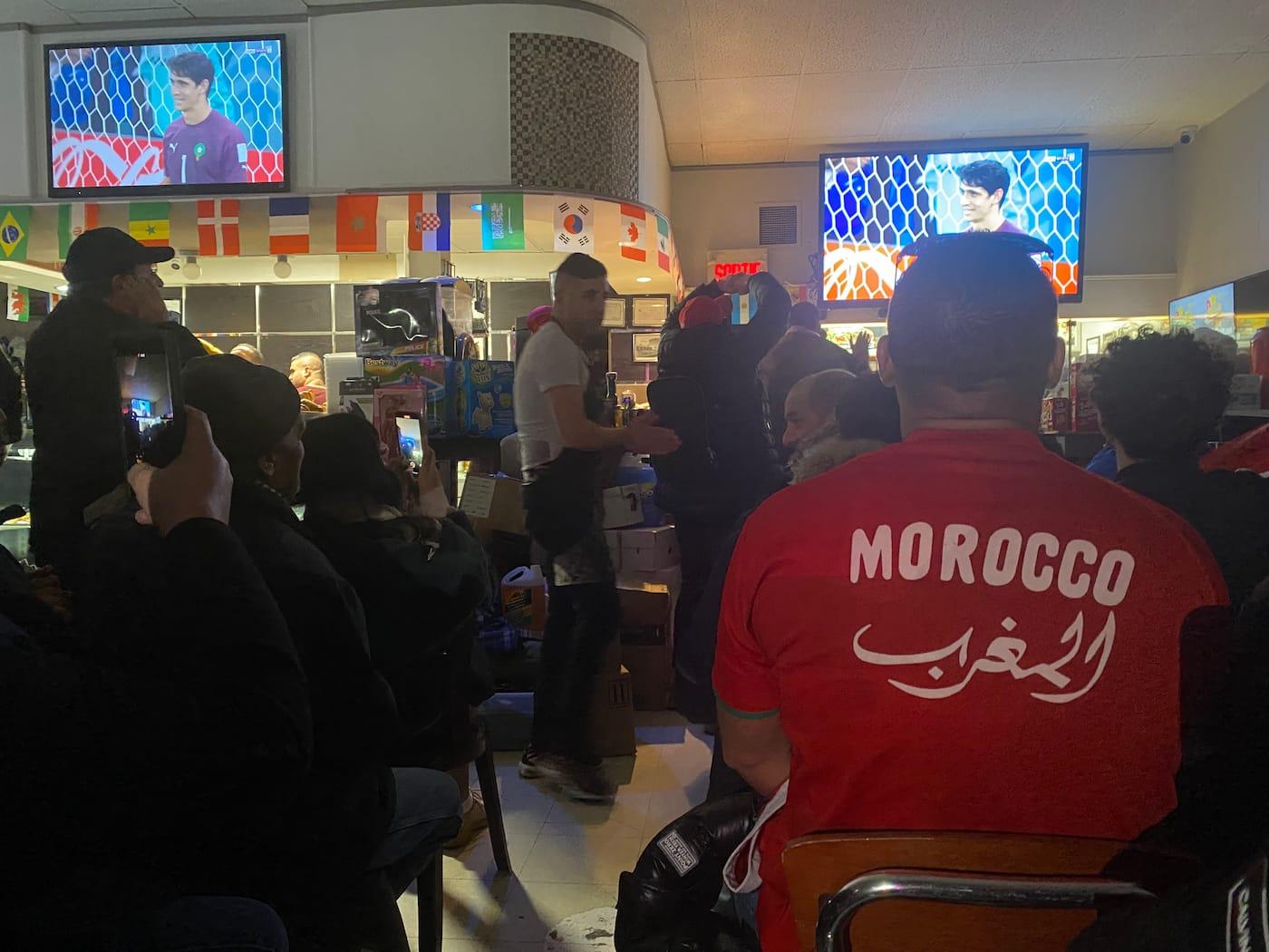 Airport mini fan zone Morocco supporters gathering food tables flags shirts language shared meal Houston